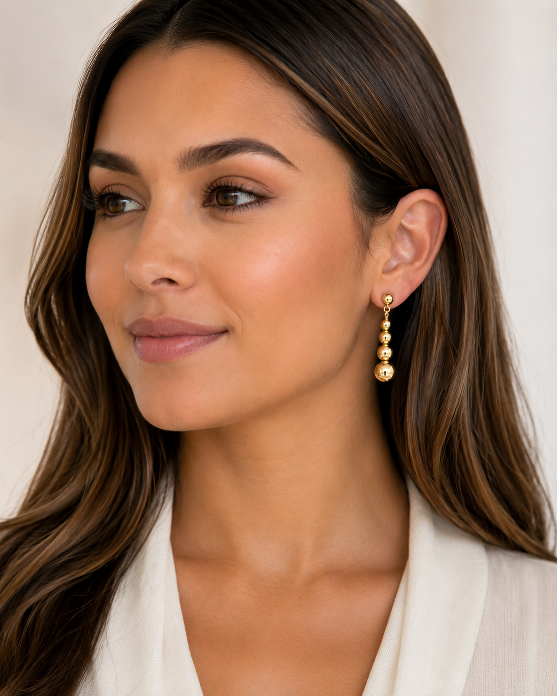 Name:
livia-gold-ball-drop-earrings-on-model
Alt text:
Model wearing Livia gold-plated sterling silver ball drop earrings with graduated polished spheres.