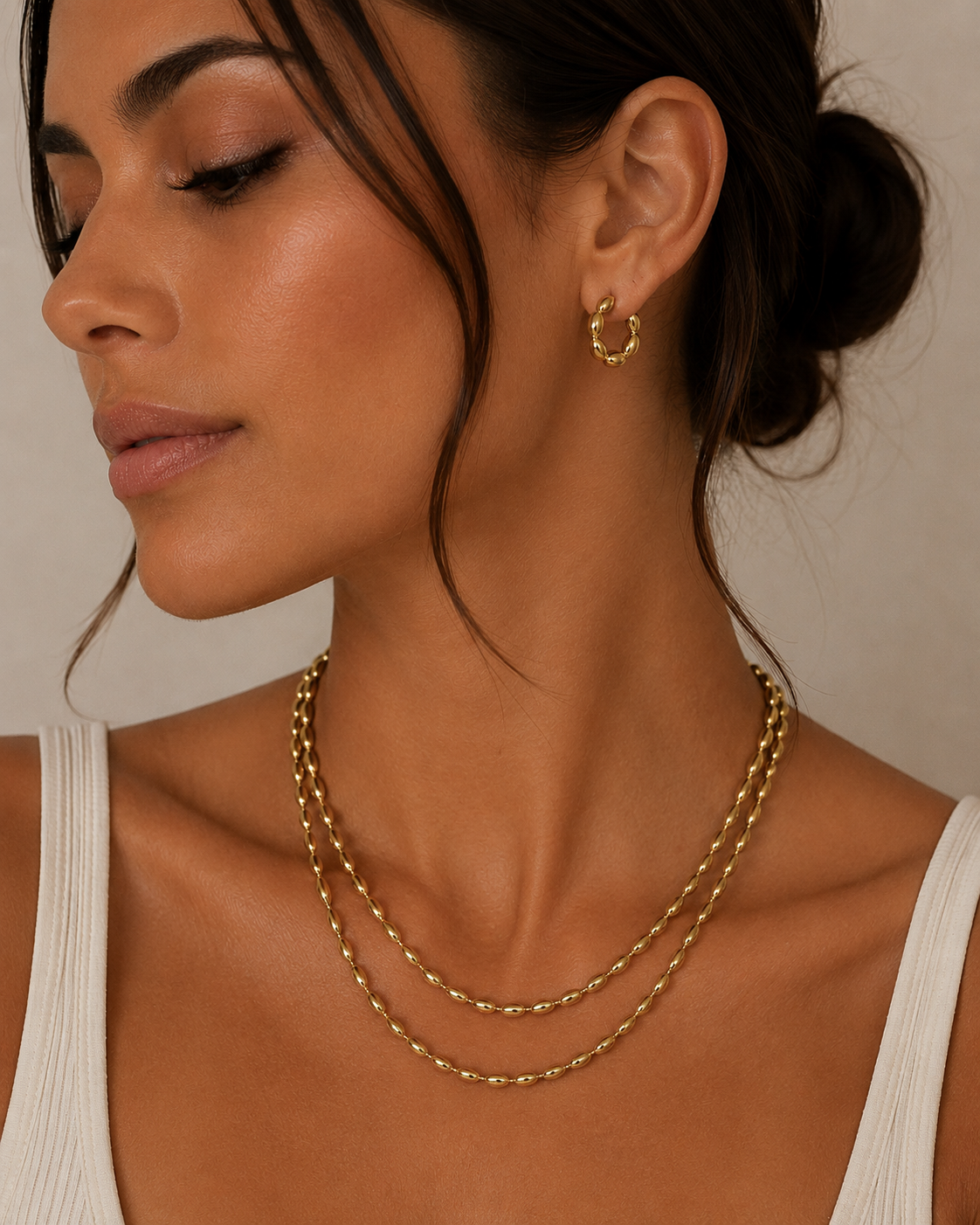 Model wearing the Veronica double-layer gold chain necklace with oval beads