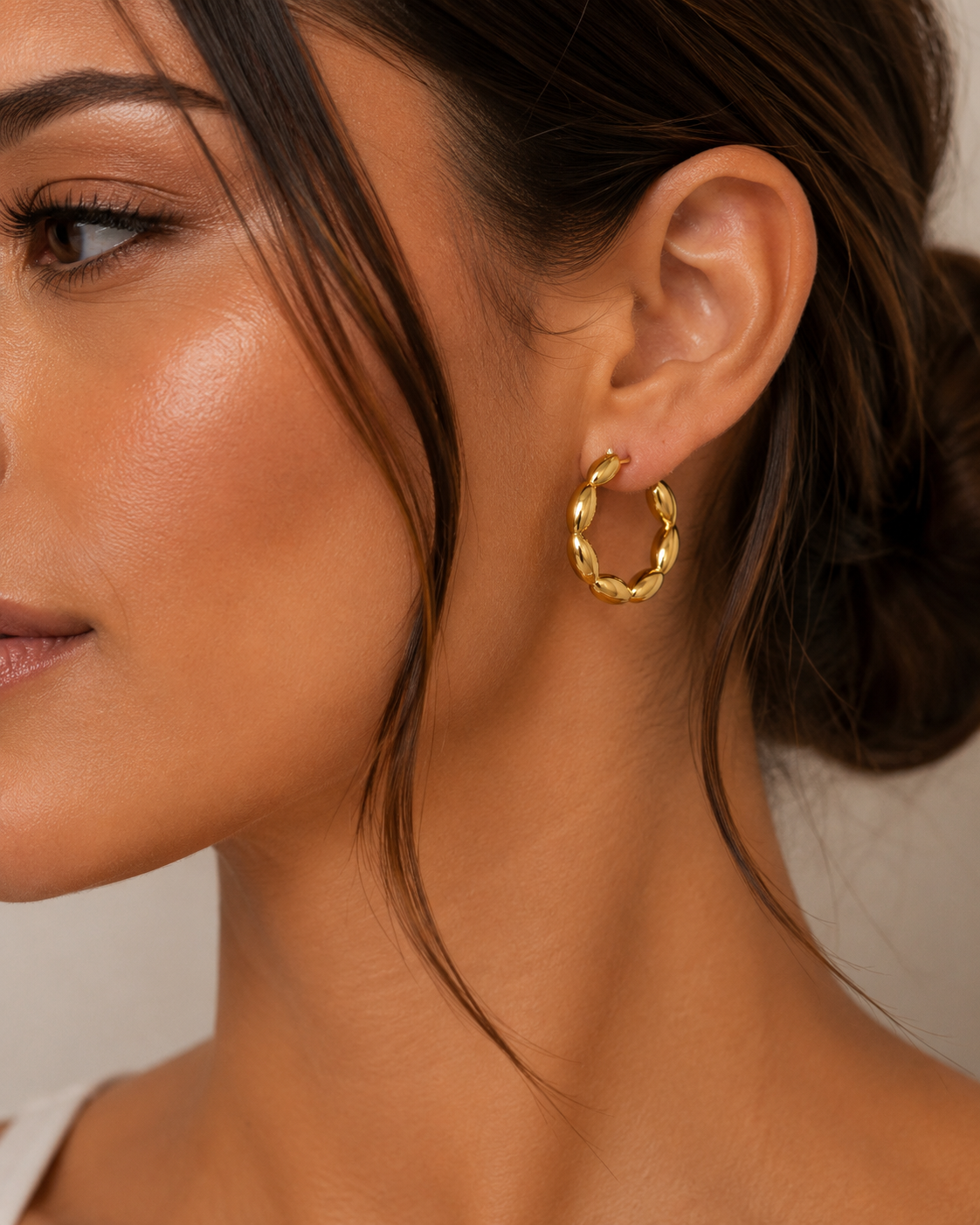 Close-up of a model wearing The Veronica Hoops with a sculptural gold oval-link design