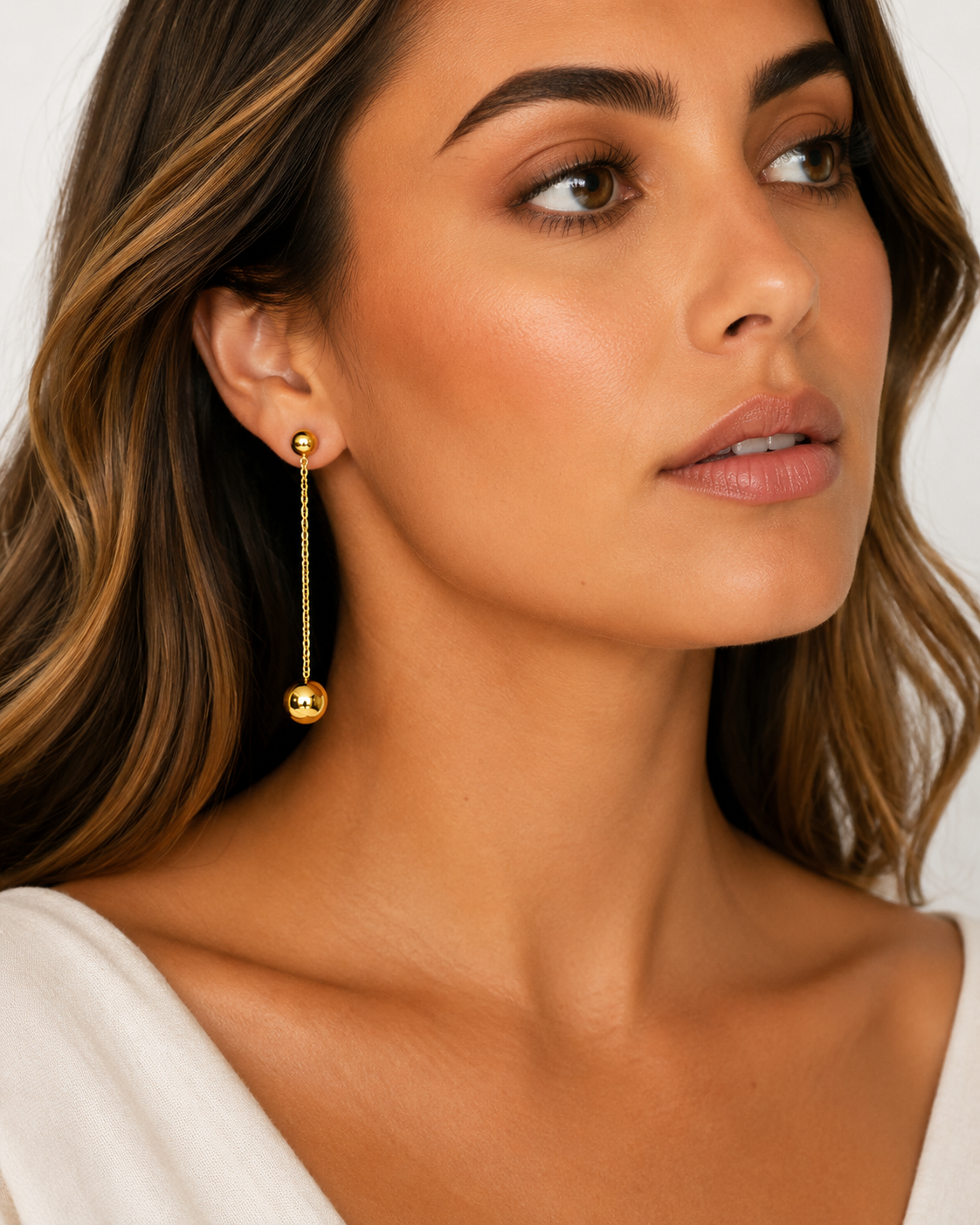  Model wearing Adrianne Convertible Double Ball Drop Earring in gold with one strand